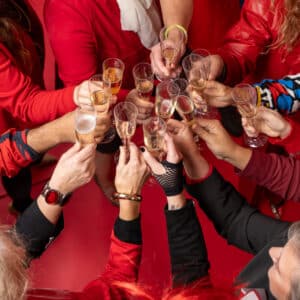 A bird's-eye view of the JayRay team's hands cheersing glasses of champagne