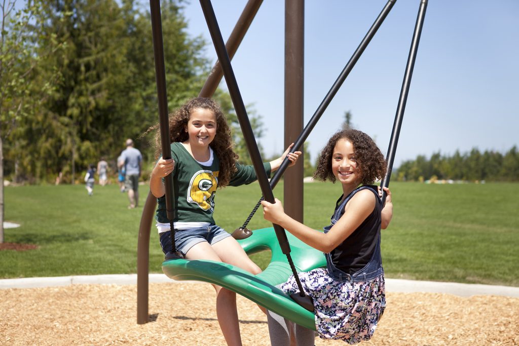 Photo of two children playing on a swing set