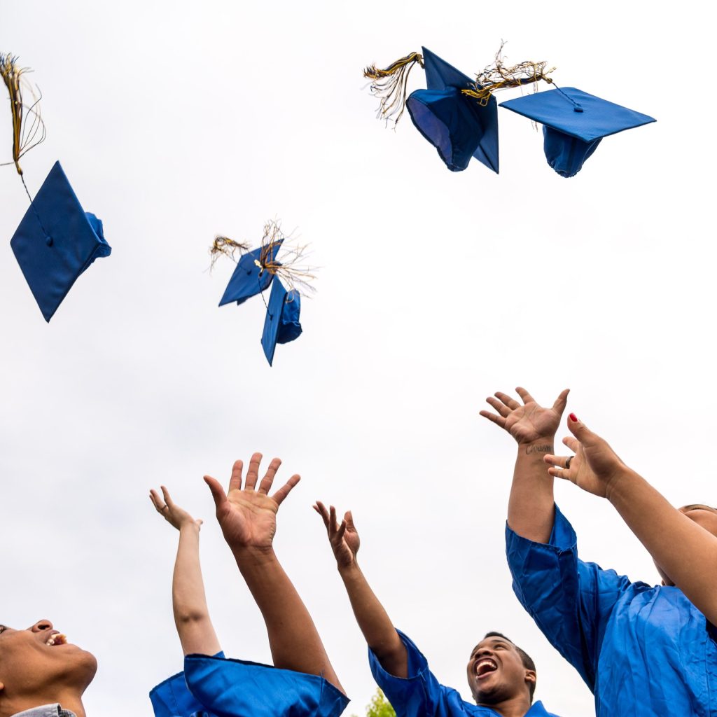 photo of Tacoma Community College students throwing their caps in the air on graduation day