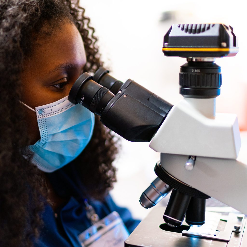 photo of a nurse looking down a microscope at Summit Pacific Medical Center
