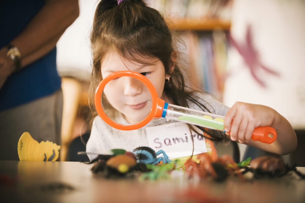 photo of a child looking through a magnifying glass