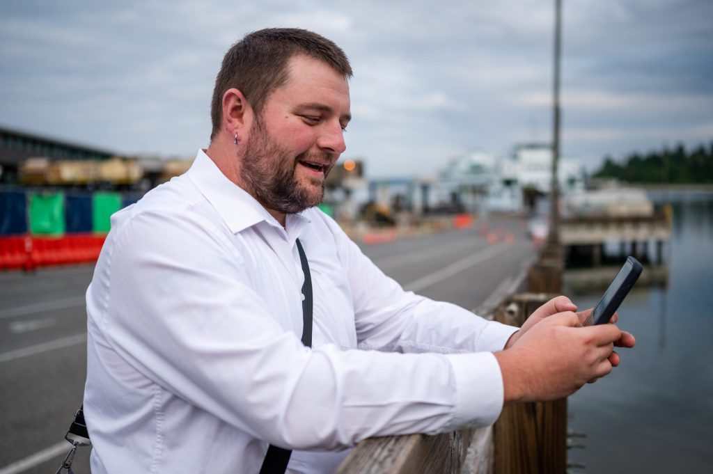 photo of a commuter using their phone while waiting for the Fast Ferry