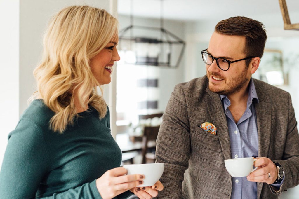 photo of two professionals talking while drinking hot drinks from tea cups