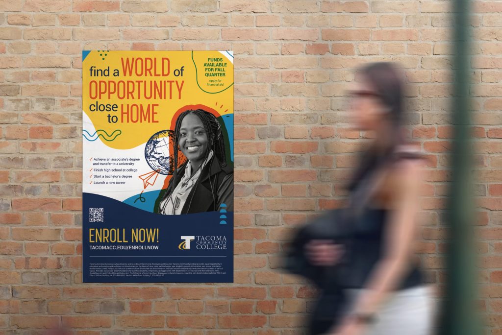 Photo of a person looking at a Tacoma Community College poster on a brick wall as they walk by