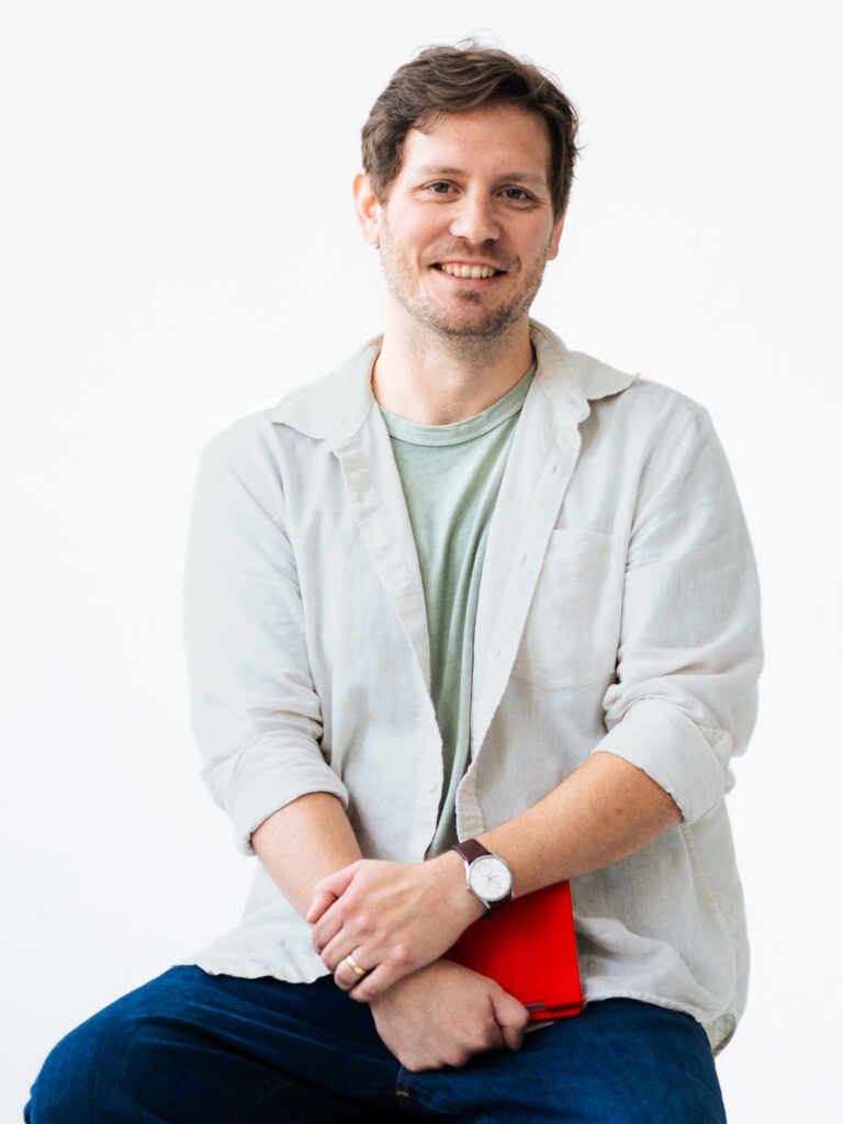 Alex Volkman posing with a red notebook