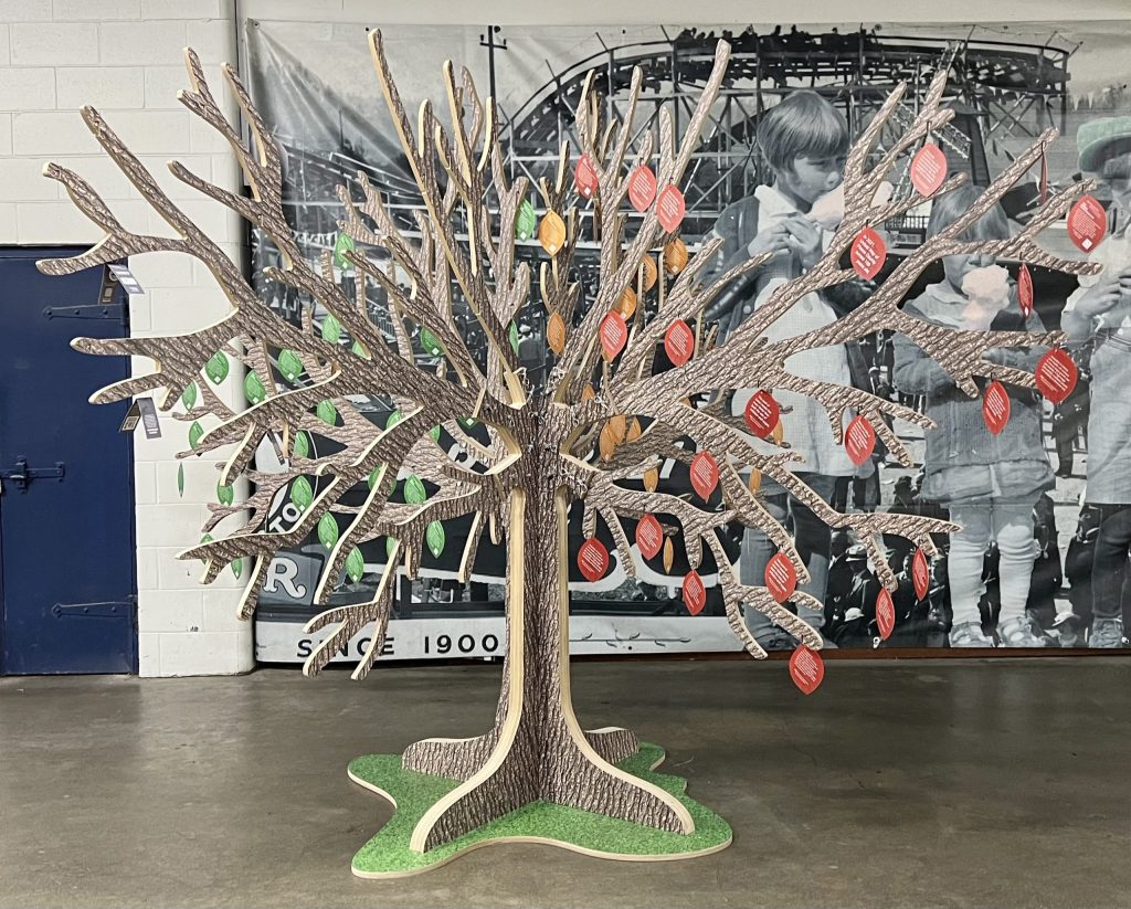 A decorative, manufactured tree designed to hold support cards that are designed to look like leaves.