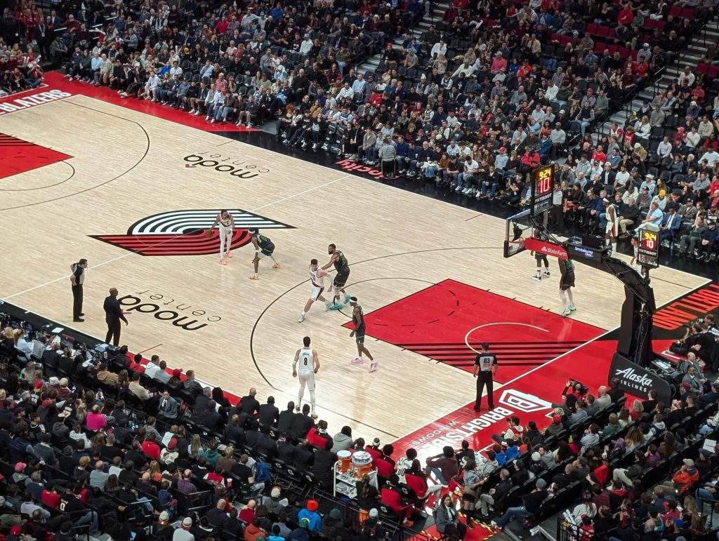 A photo taken from the stands at moda center showing the Portland Trail Blazers playing basketball.