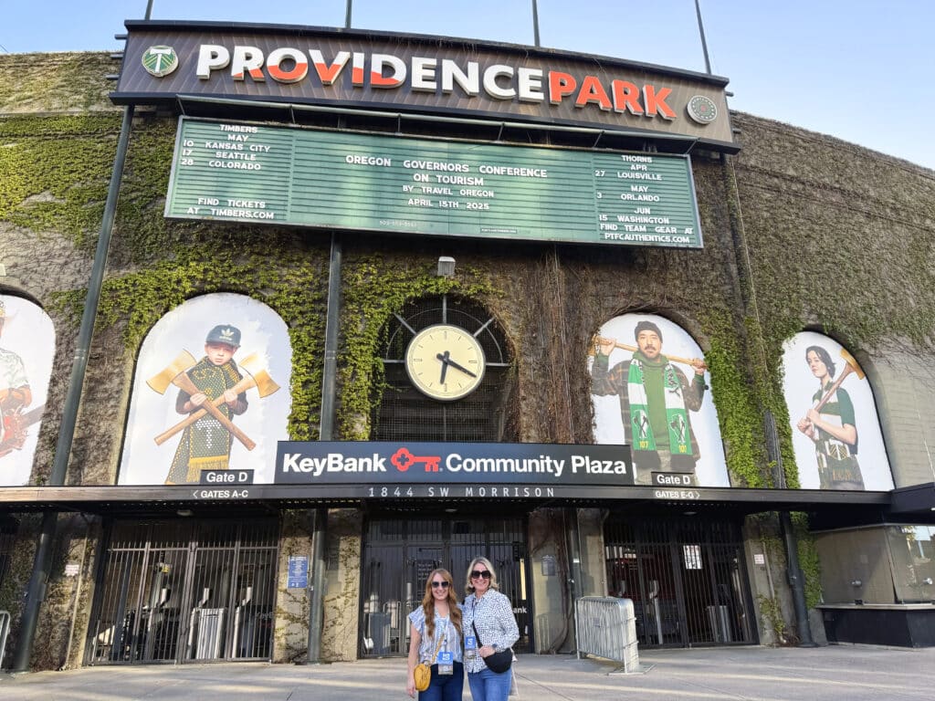 Bridget Baeth and Jen Willey pose in front of Providence Park during the Oregon Governor's Conference on Tourism